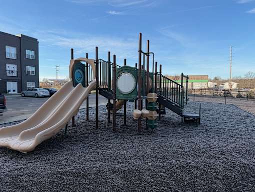 A playground with a slide and a green and white structure.