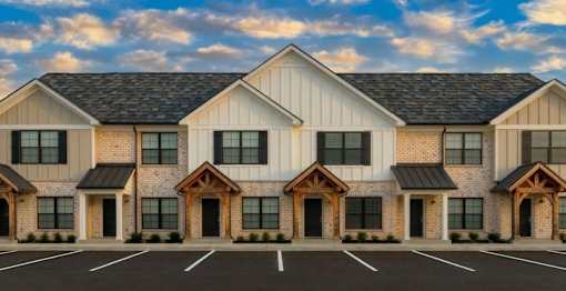 A row of houses with a parking lot in front.