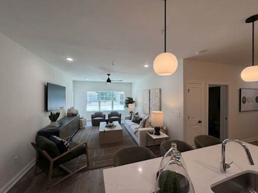A modern living room with a kitchen area in the foreground.