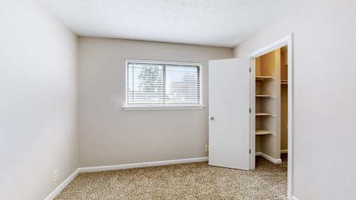 an empty room with a closet and a window