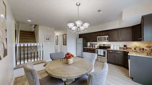 A modern kitchen with dark brown cabinets and a wooden dining table.