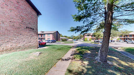 the corner of a street with a brick building and a tree