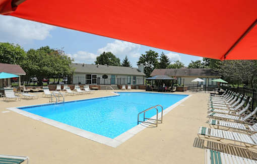A large outdoor swimming pool with lounge chairs and umbrellas.