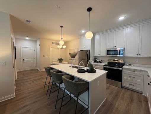 A kitchen with a table and chairs in the middle of it.