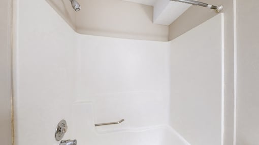 a white bathroom with a tub and a shower in it