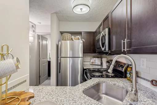 A kitchen with stainless steel appliances at Avenue in the Highlands Apartments in Louisville