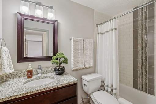 A bathroom with toilet and sink  at Avenue in the Highlands Apartments in Louisville