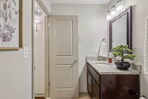 A bathroom with a sink and mirror  at Avenue in the Highlands Apartments in Louisville