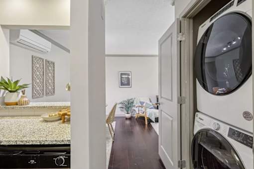 A laundry room with a washer and dryer  at Avenue in the Highlands Apartments in Louisville