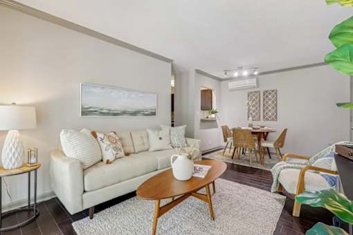 A living room with a white couch and a painting on the wall  at Avenue in the Highlands Apartments in Louisville