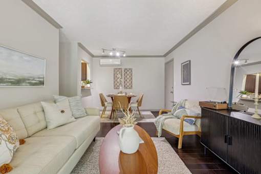 A living room with a white couch, wood coffee table and mirror in Lexington, KY.