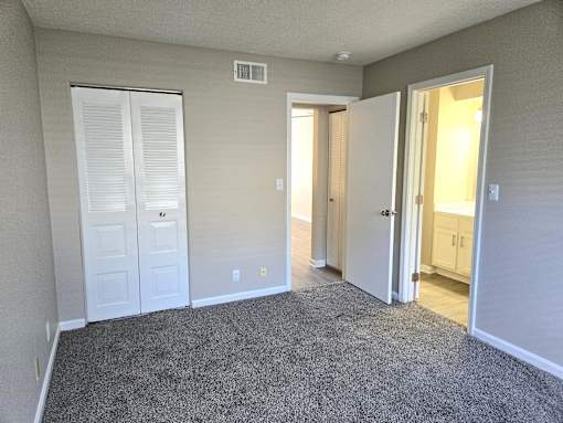 A room with a grey carpet and white walls.