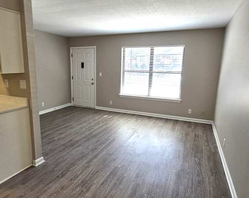 A room with a door and a window with blinds.