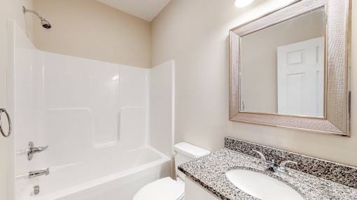 A white bathroom with a sink, toilet, and bathtub.