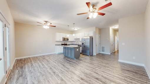 A spacious kitchen with a blue island in the middle.