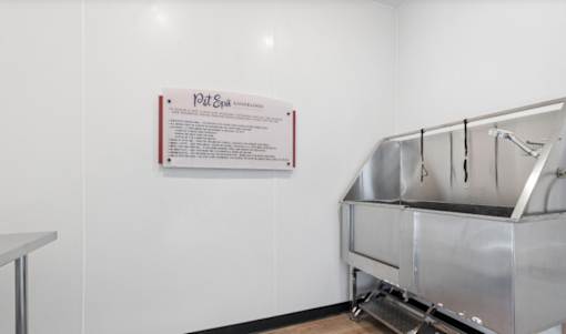 A stainless steel sink in a room with a sign on the wall.