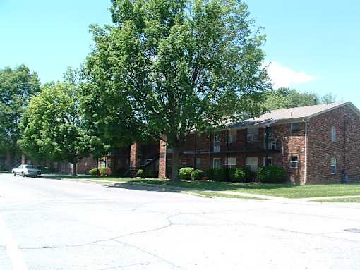 a red brick building with a tree in front of it