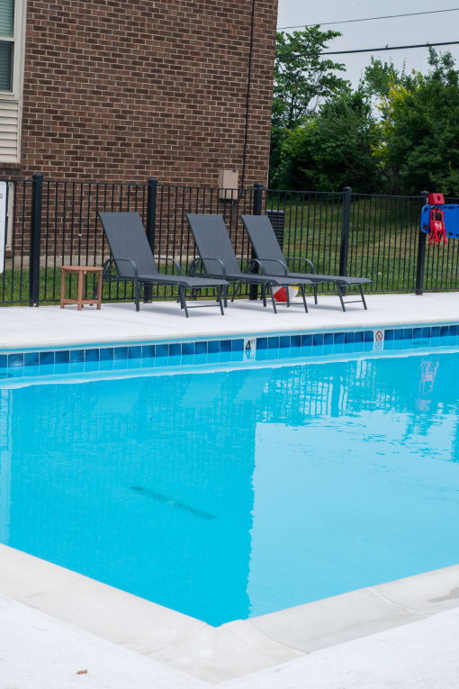 the swimming pool at our house with chairs and a blue pool