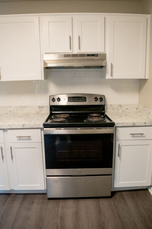 Renovated kitchen with white cabinets and a stainless steel stove