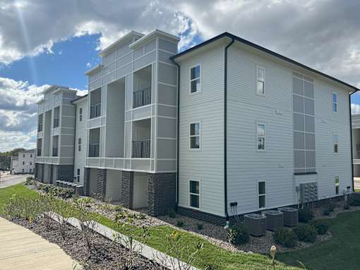 Apartment building with a walkway in front.