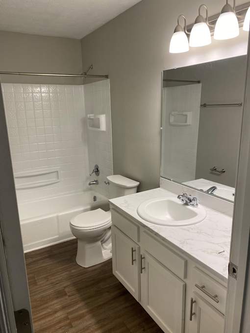 A white toilet and sink in a bathroom.