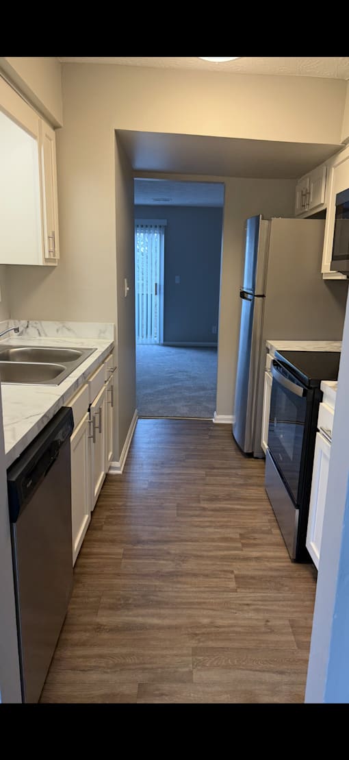 A kitchen with a black fridge and a black oven.
