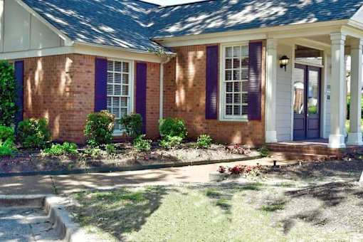 A house with purple shutters and a white door.