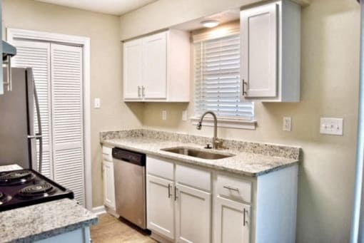 a kitchen with white cabinets and a sink