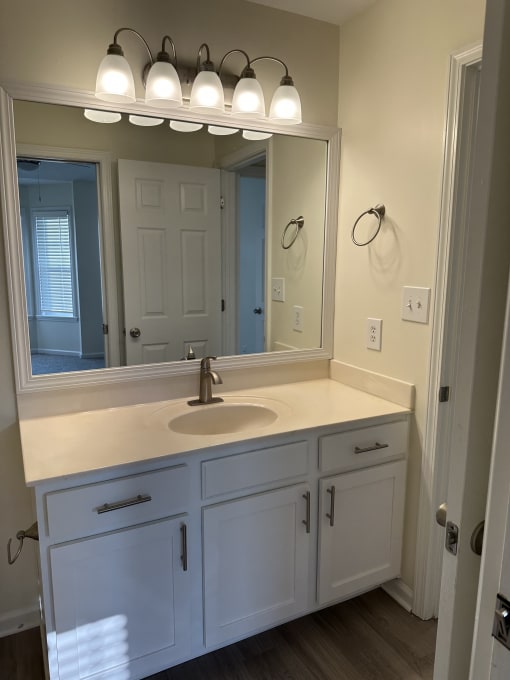 a small bathroom with a large mirror and a white door