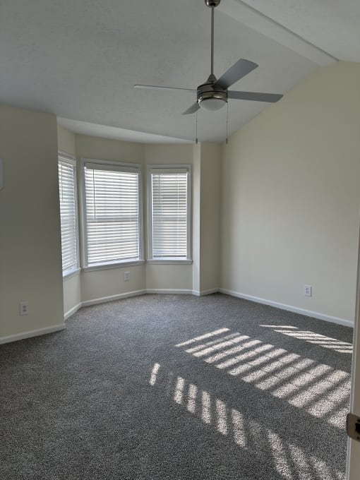 a room with a window and a ceiling fan