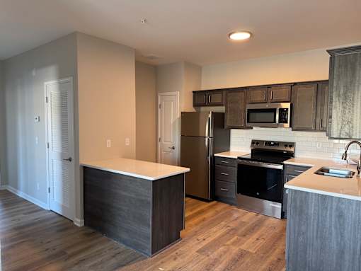 A kitchen with a refrigerator, oven, and microwave.