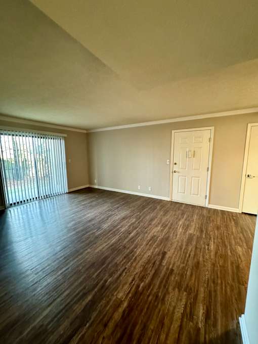 A room with wooden flooring and white walls.