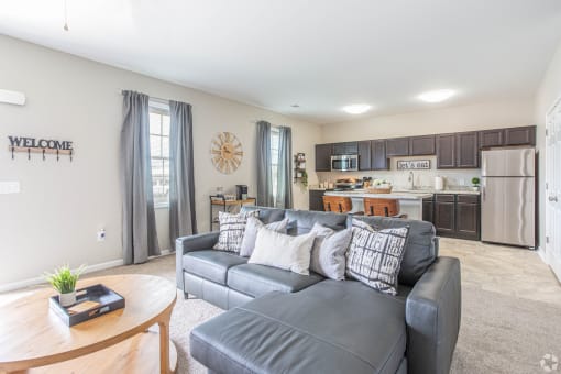 a living room with a couch and a kitchen