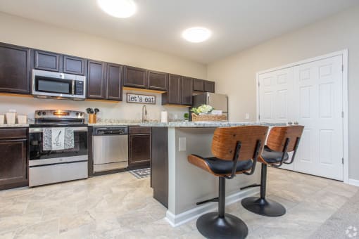 a kitchen with a counter top with two bar stools