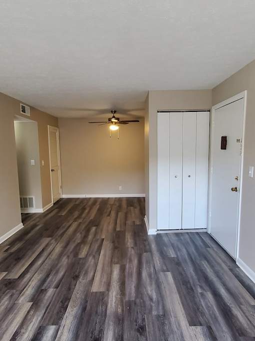 A room with a ceiling fan and two doors.