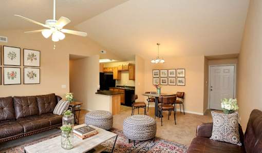 A living room with a brown leather couch and a white coffee table.
