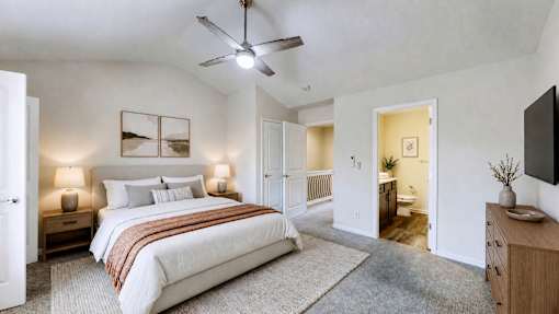 A bedroom with a large bed and a ceiling fan.