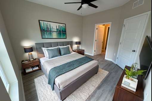 A bedroom with a large bed and a ceiling fan.
