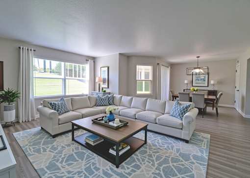 A living room with a large sectional sofa and a coffee table.