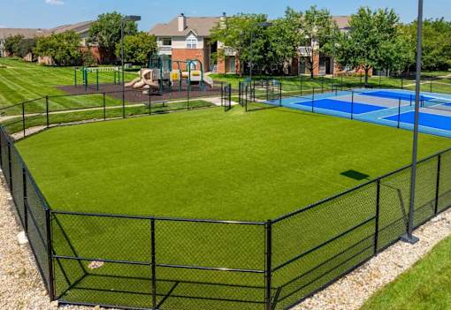 A black fenced in area with a blue pool in the middle.