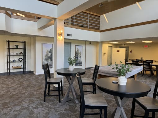 a living room with tables and chairs and a bed