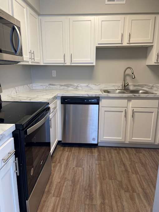 A kitchen with a black oven and a stainless steel dishwasher.