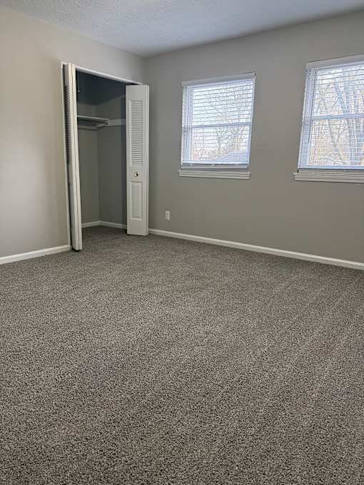A room with a carpeted floor and a white door.