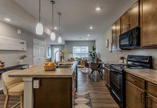 A kitchen with a wooden island and black appliances.