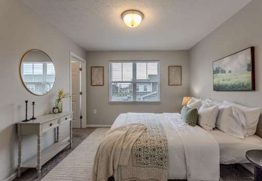 A bedroom with a large bed and a window overlooking a cityscape.
