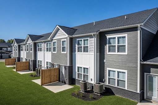 A row of houses with grey siding and white trim.