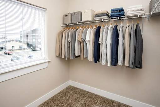 A row of clothes hangs on a rack in a room.