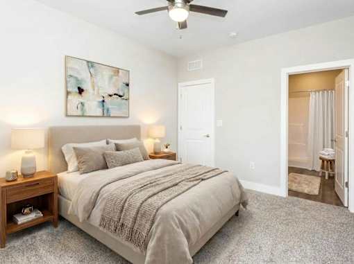A bedroom with a large bed and a ceiling fan.