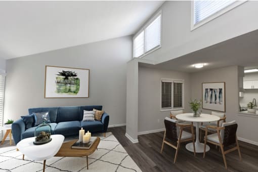 a living room with a blue couch and a dining room table