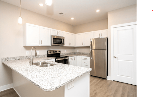 A kitchen with a granite countertop and stainless steel appliances.